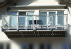 vorgehängter Balkon mit Holzboden und Glasgeländer